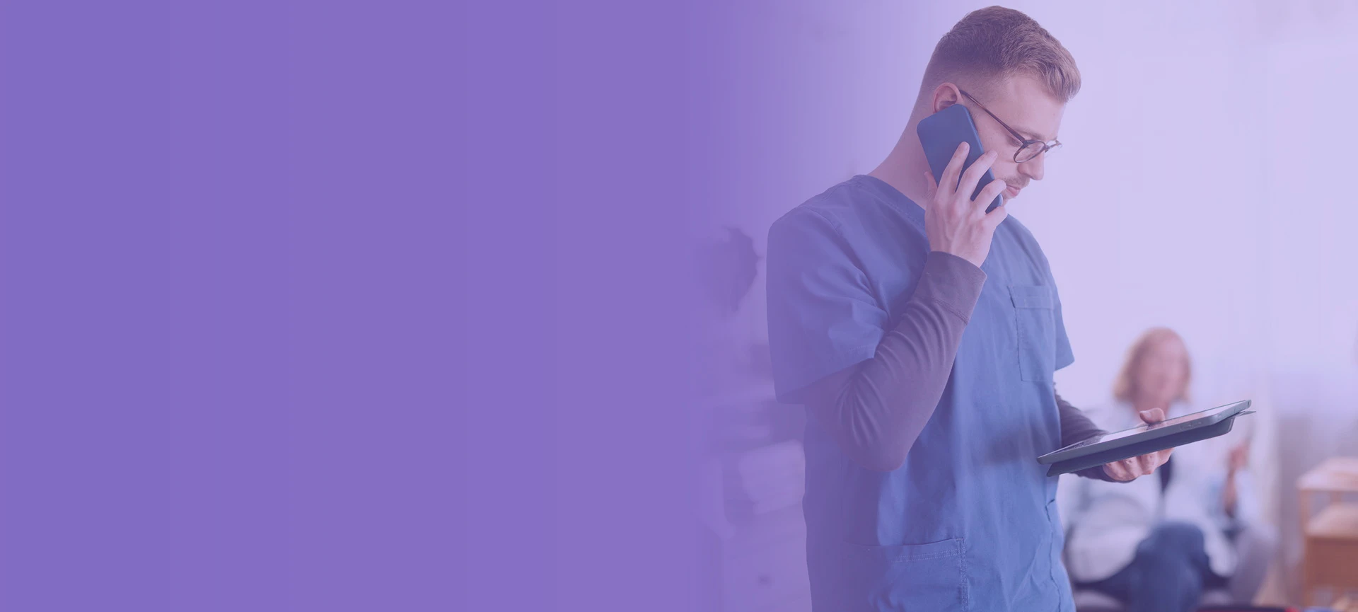Care home worker using a mobile phone and tablet to update a colleague while a resident sits nearby